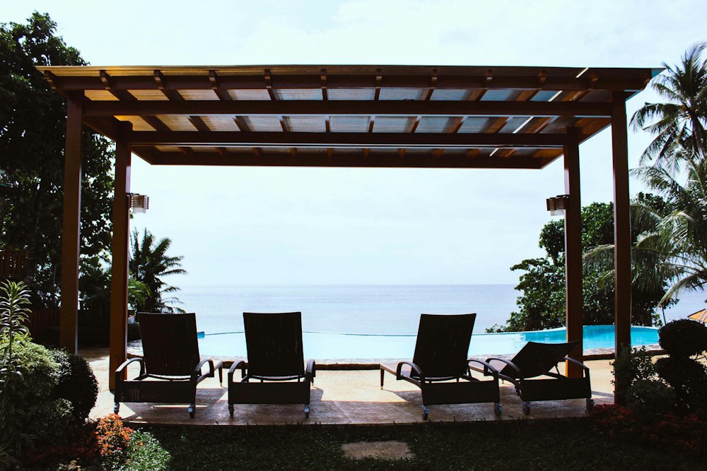 Terraza con pérgola junto a una piscina