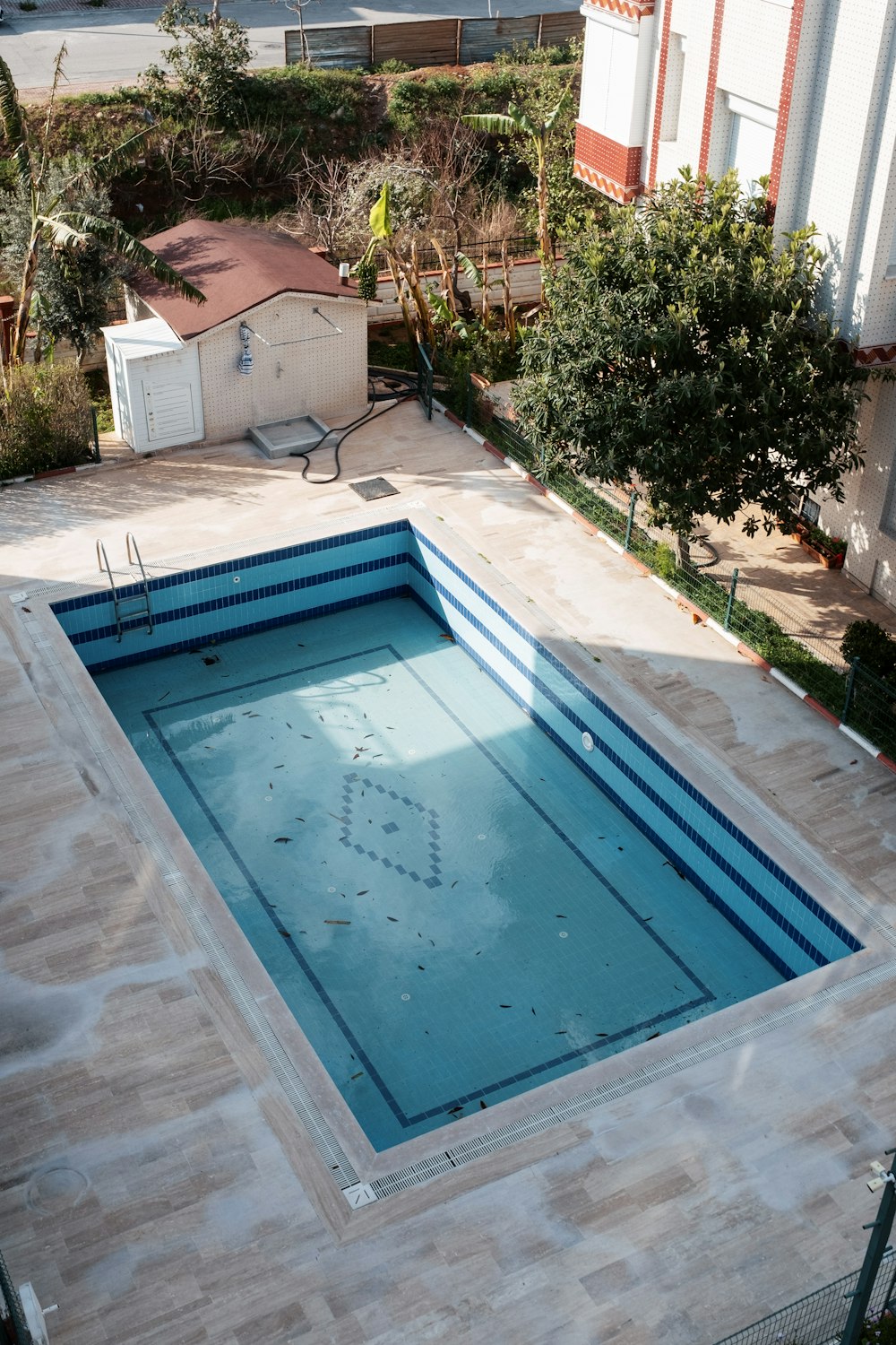 Piscina de hormigón con borde de piedra en un patio de su comuna
