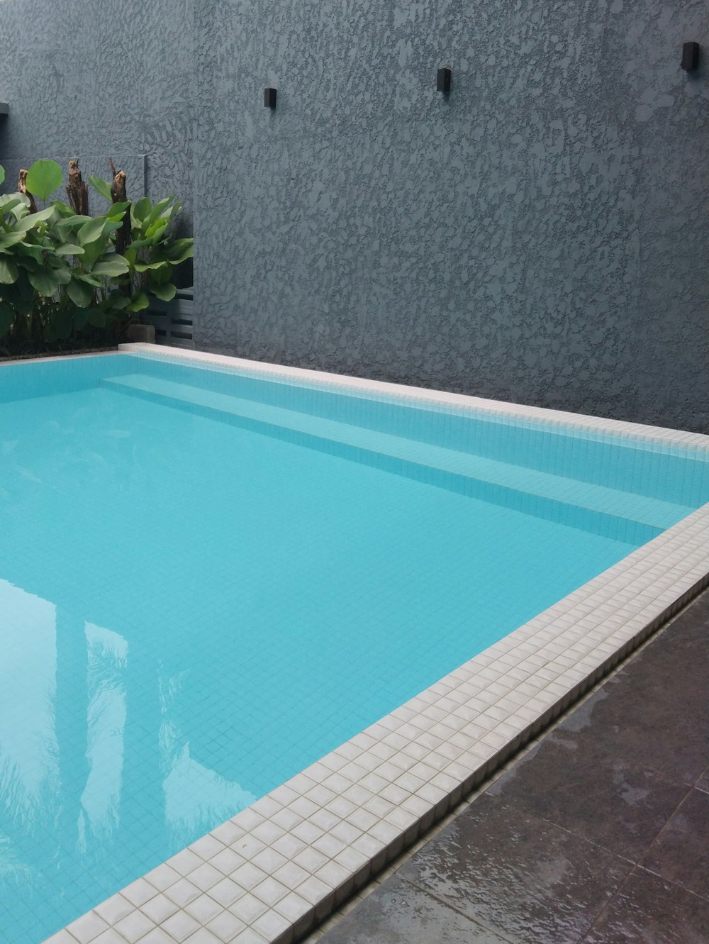 Piscina rectangular de agua clara junto a un muro
